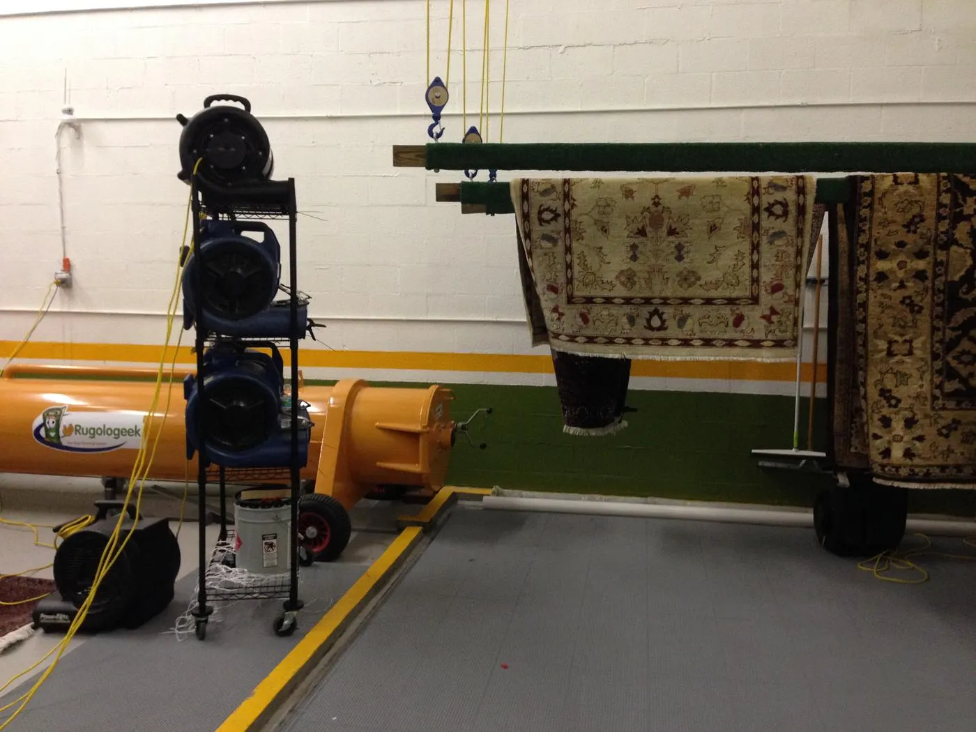 Rugs hanging on poles in the controlled drying room