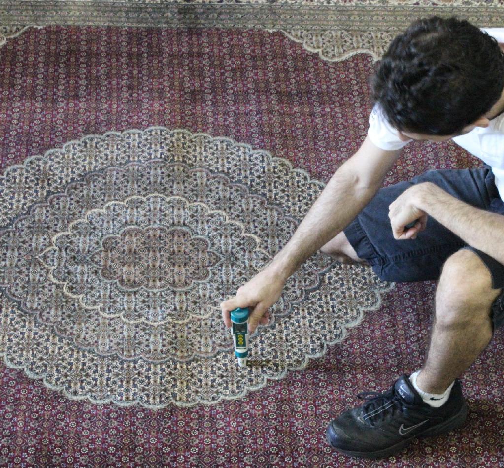 Technician pH-testing an Oriental rug before washing