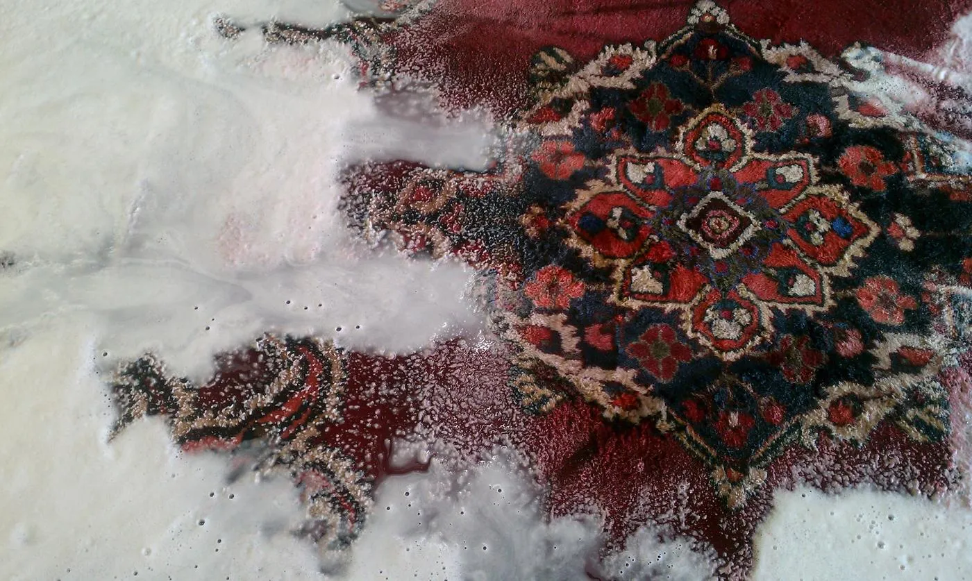 Persian rug mid-wash, covered in shampoo suds at the Weston shop
