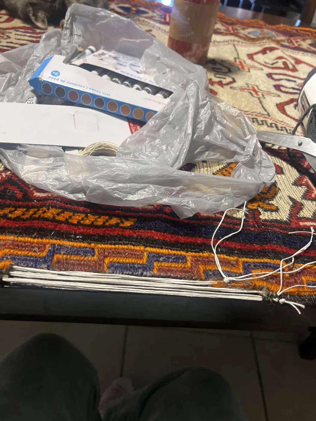 New warp threads laid out across a rug end on the repair table
